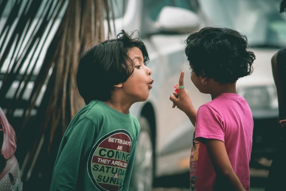 Two children talking together outdoors