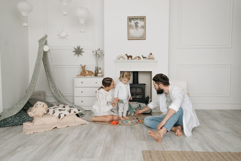 Two parents playing on the floor with their child