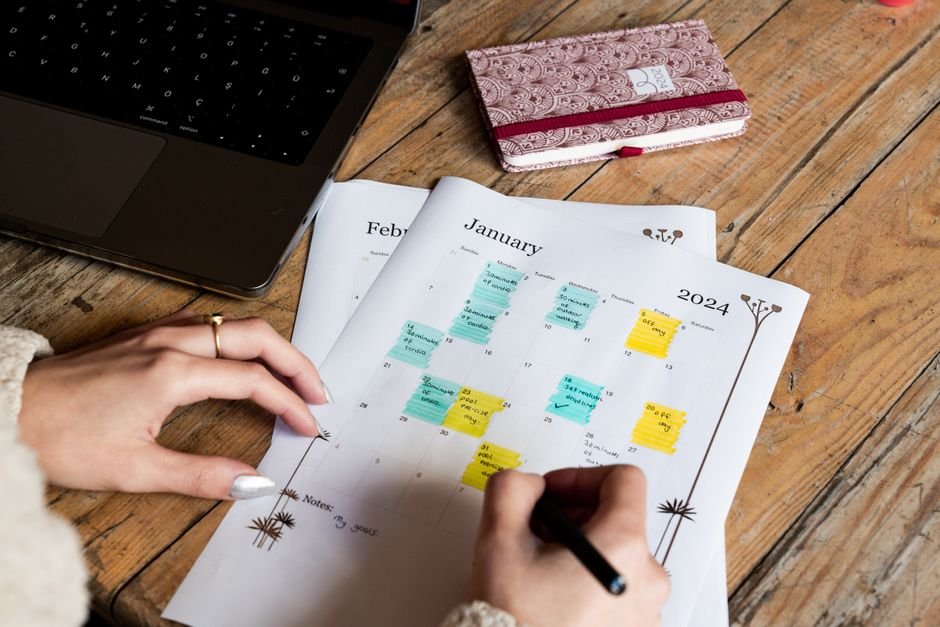 A wall calendar covered in handwritten notes